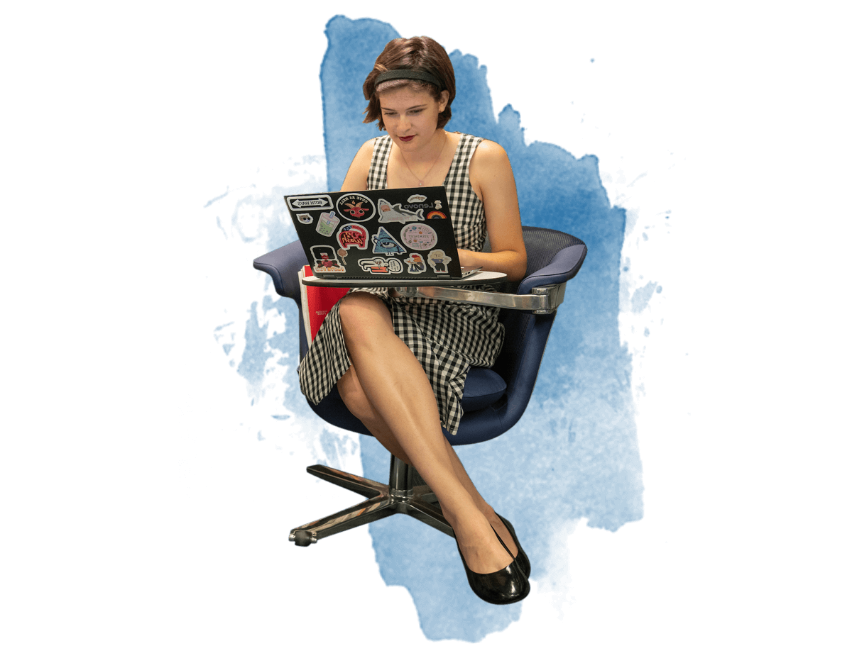 一个女学生坐在椅子上用笔记本电脑工作